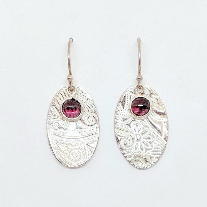 Textured Small Oval Earrings with Garnet in Bezel by Veronica Stewart at The Avenue Gallery, a contemporary fine art gallery in Victoria, BC, Canada.