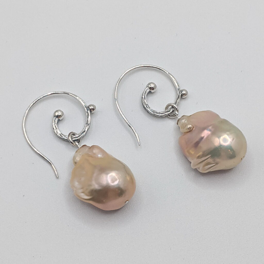 Baroque Pearl Earrings in Pink set with a Curly Silver Wire by Val Nunns at The Avenue Gallery, a contemporary fine art gallery in Victoria, BC, Canada.