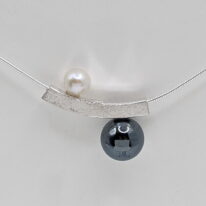 Balanced Yin-Yang Necklace with White Pearl & Hematite by Chi's Creations at The Avenue Gallery, a contemporary fine art gallery in Victoria, BC, Canada.