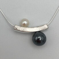 Balanced Yin-Yang Necklace with White Pearl & Hematite by Chi's Creations at The Avenue Gallery, a contemporary fine art gallery in Victoria, BC, Canada.